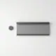 Composición minimalista con un cassette de persiana y un control inalámbrico, mostrando opciones de motorización recomendables para comercios.